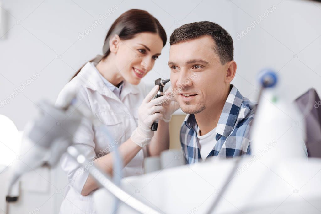 otolaryngologist touching ear of her patient