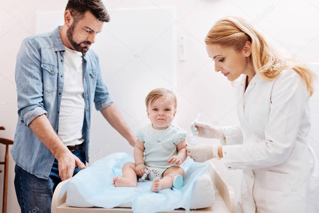 doctor giving inoculation to little patient