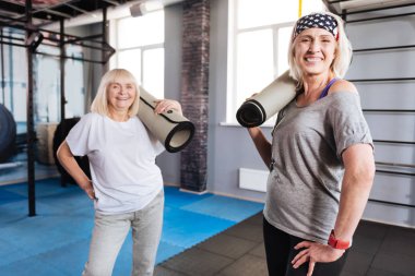 Yoga paspaslar holding neşeli yaşlı kadın