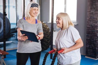 Bir tablet tutan neşeli yaşlı kadın