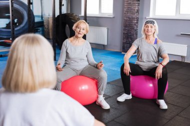 Hoş iyi görünümlü kadın fitness topları üzerinde oturuyordu