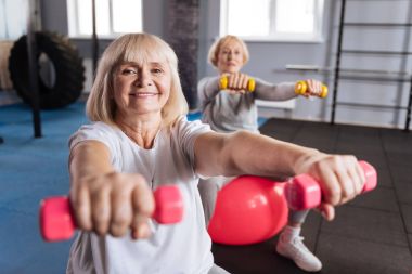 Pembe dumbbells tutan neşeli enerjik kadın