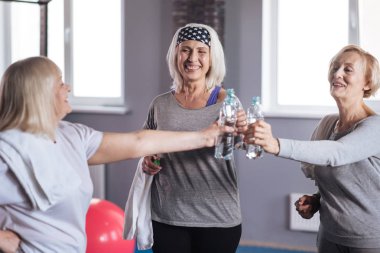 Neşeli mutlu kadın şişe su ile tutarak