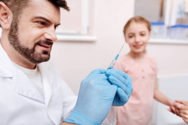 Çocuk doktoru holding şırınga gülümseyen portresi