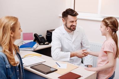 Onun hasta elini tutarak yakışıklı çocuk doktoru