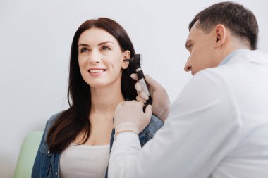 Özenli doktor güzel kadının kulak sınav yapıyor