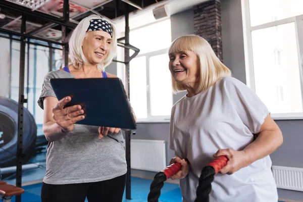 Happy delighted woman looking at the tablet screen