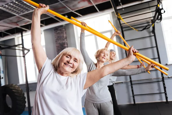 Femei în vârstă sportivă care dețin bețe de gimnastică — Fotografie, imagine de stoc