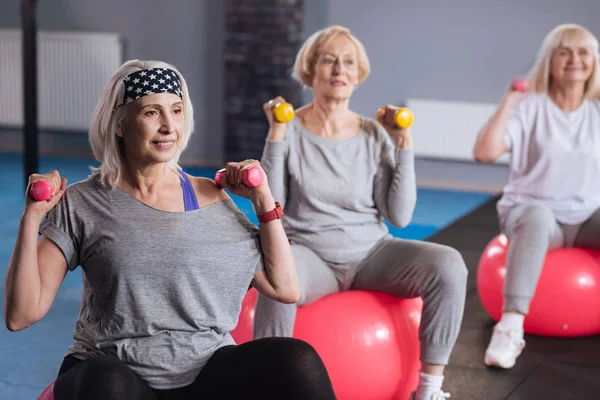 Mujeres confiadas y persistentes que hacen ejercicio con pesas — Foto de Stock