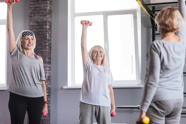 Agradables mujeres deportivas haciendo ejercicio en un club de fitness —  Fotos de Stock