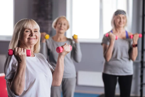 Feliz mujer fuerte de pie con pesas — Foto de Stock