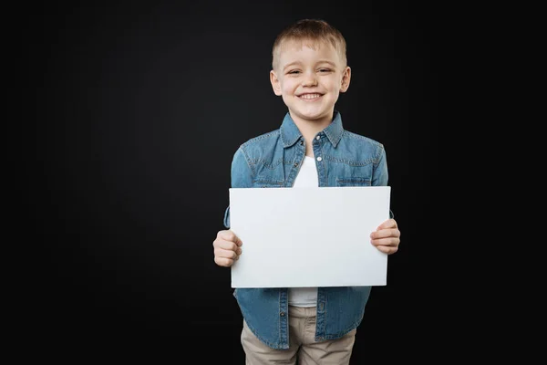 Gelukkige jongen holding Witboek blad — Stockfoto