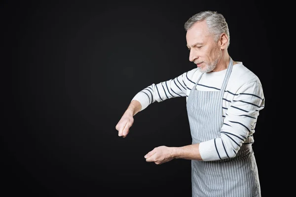 Uomo serio che immagina che tenere gli strumenti da cucina — Foto Stock