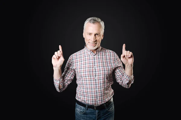 Good-looking man standing against black background — Stock Photo, Image