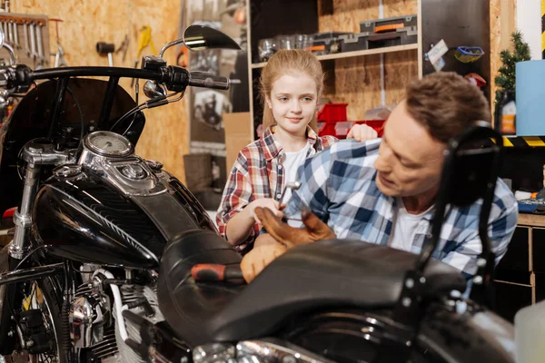 Ondersteuning van actieve meisje overhandigen van haar vader een moersleutel — Stockfoto