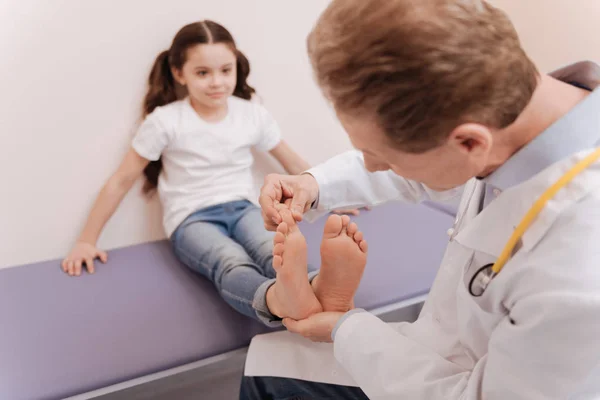 Médico escrupuloso metódico examinando dedos das meninas — Fotografia de Stock