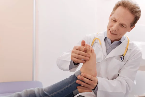 Friendly careful rheumatologist making sure patient being healthy — Stock Photo, Image