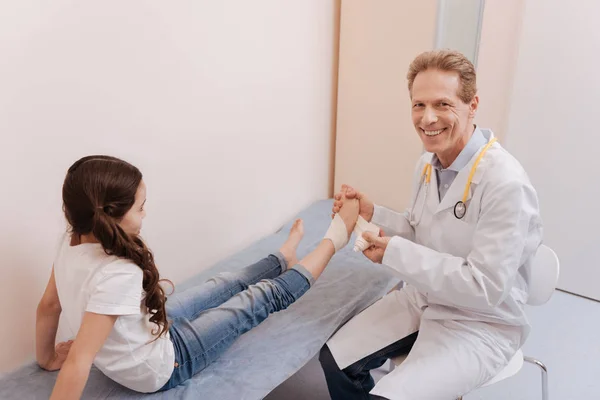 Diligente medico positivo avvolgente ragazze piede in schiavitù — Foto Stock