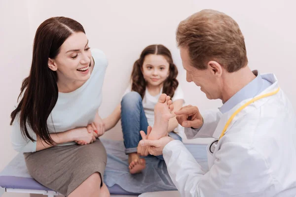 Entusiasta donna graziosa ascoltando ciò che dice il medico — Foto Stock