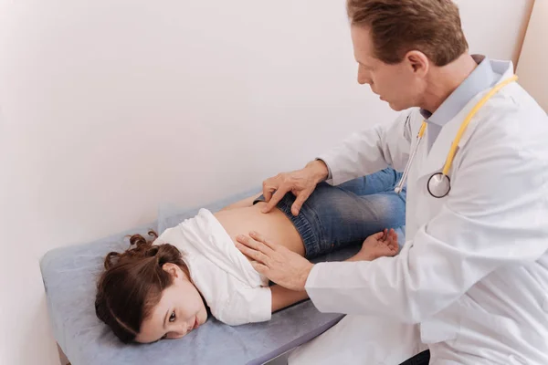 Cuidar al reumatólogo habilidoso revisando la columna vertebral de los pequeños pacientes — Foto de Stock