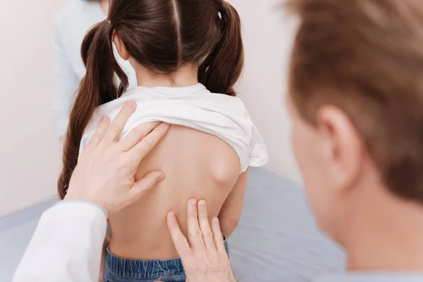 Gentle neat rheumatologist making sure girls spine being healthy — Stock Photo, Image