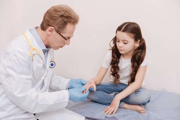 Ernstige bevoegde man meisjes handen onderzoeken — Stockfoto