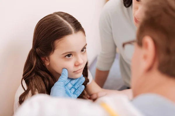 Dermatólogo prominente examinar cuidadosamente la cara de las niñas —  Fotos de Stock