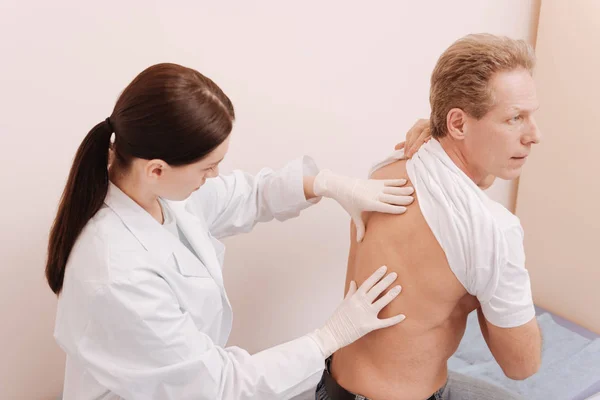 Observant careful rheumatologist looking for cause of pain — Stock Photo, Image