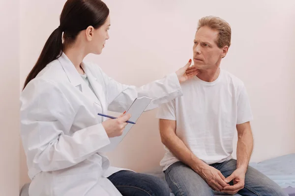 Observant careful doctor looking at mans skin — Stock Photo, Image