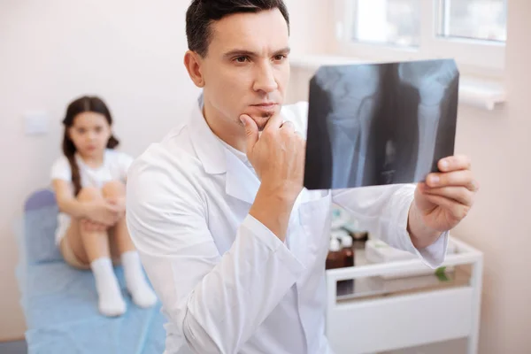 Reumatologista pensativo sério examinando uma foto de raios X — Fotografia de Stock