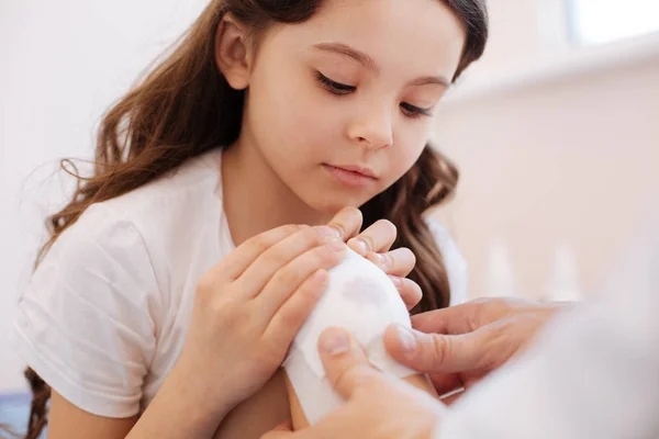 Bella ragazza curiosa osservando il trattamento della ferita — Foto Stock