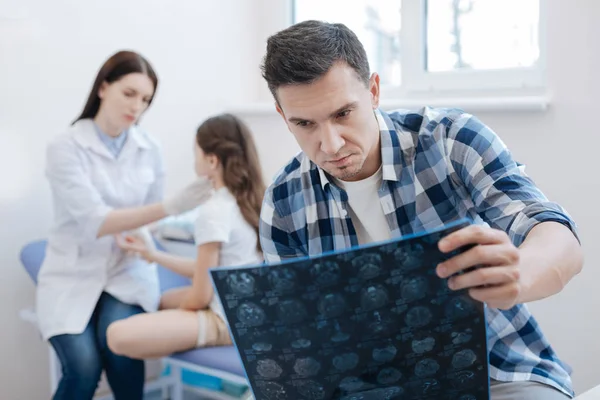 Agradable hombre guapo mirando la imagen de rayos X — Foto de Stock