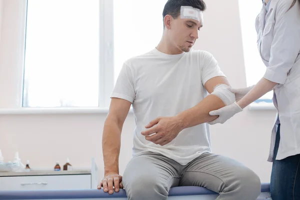 Cheerless wounded man looking at his injury — Stock Photo, Image
