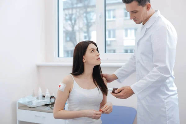 Serious nice doctor holding a bottle with medicine — Stock Photo, Image