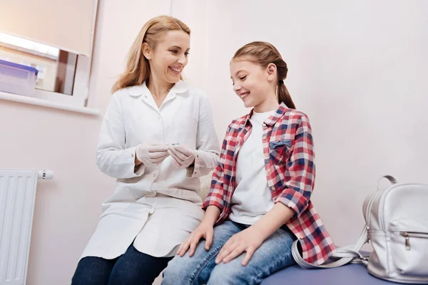 Sonriente paciente pequeño médico visitante — Foto de Stock