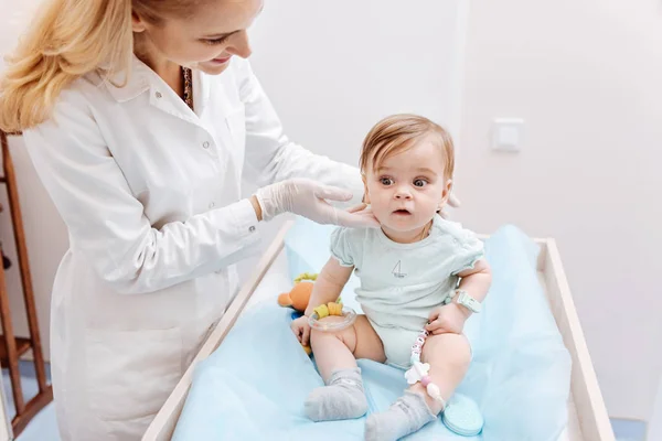 Schöne Hausärztin, die ihren kleinen Patienten behandelt — Stockfoto