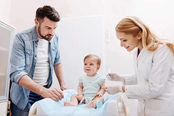 Scared child sitting between father and nurse — Stock Photo, Image