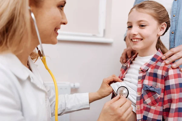 Retrato de una pequeña paciente sonriente mirando a su médico — Foto de Stock