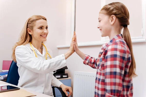 Happy female patient touching hands with her pediatrician — Stock Photo, Image