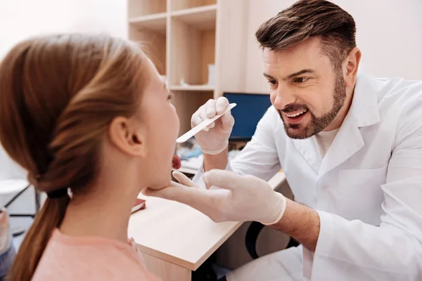 Knappe dokter luisteren naar zijn jonge patiënt — Stockfoto