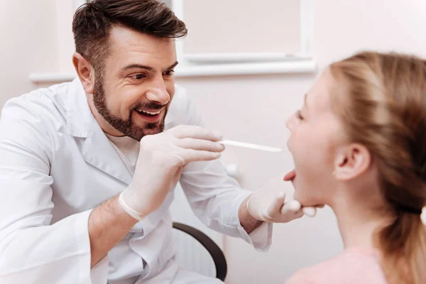 Attentive pediatrician doing throat exam — Stock Photo, Image