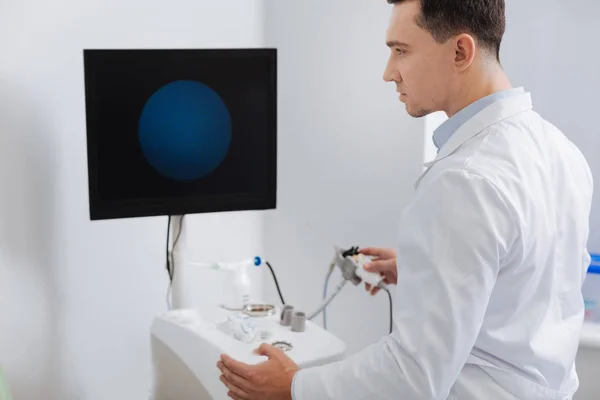 Joven médico serio trabajando con una máquina especial —  Fotos de Stock