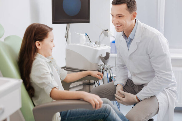 Positive delighted doctor looking at his patient