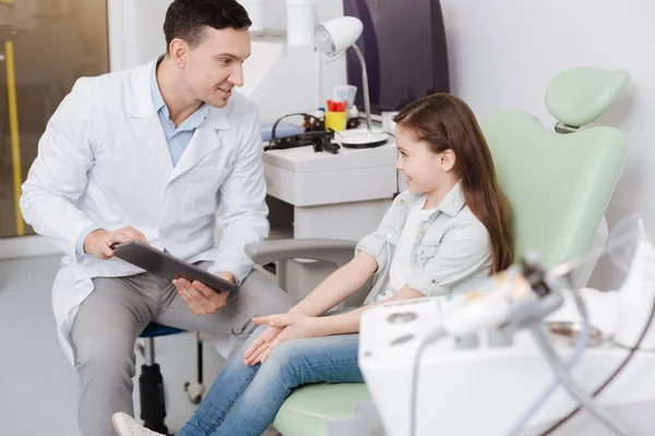 Pequena paciente bonita sorrindo para seu médico — Fotografia de Stock