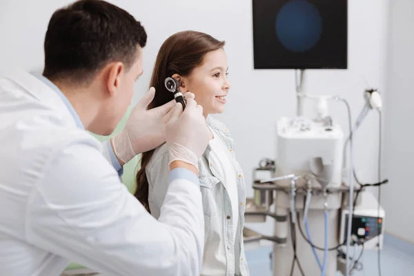 Médico atento segurando otoscópio na mão direita — Fotografia de Stock