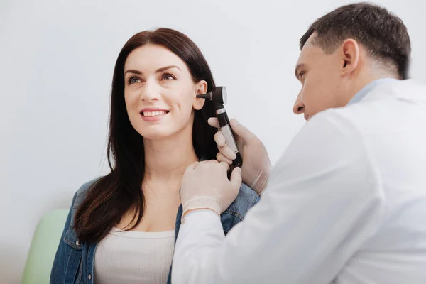 Médico atencioso fazendo exame de orelha de mulher bonita — Fotografia de Stock