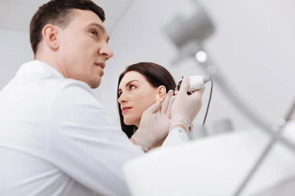 Imagen de bajo ángulo del médico profesional que revisa el oído femenino — Foto de Stock