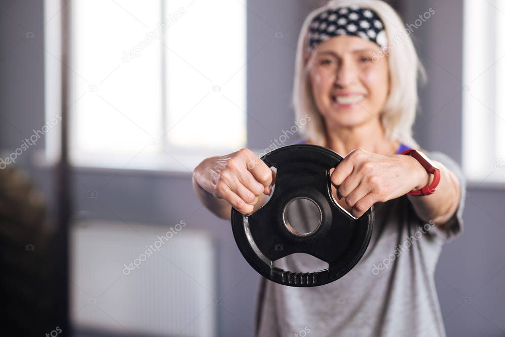 Weight disc being in hands of a nice pleasant woman