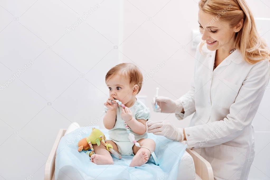 Playful baby putting toy into mouth