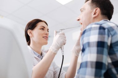 Çekici otolaryngologist erkek hastanın boğaz sınav yapıyor